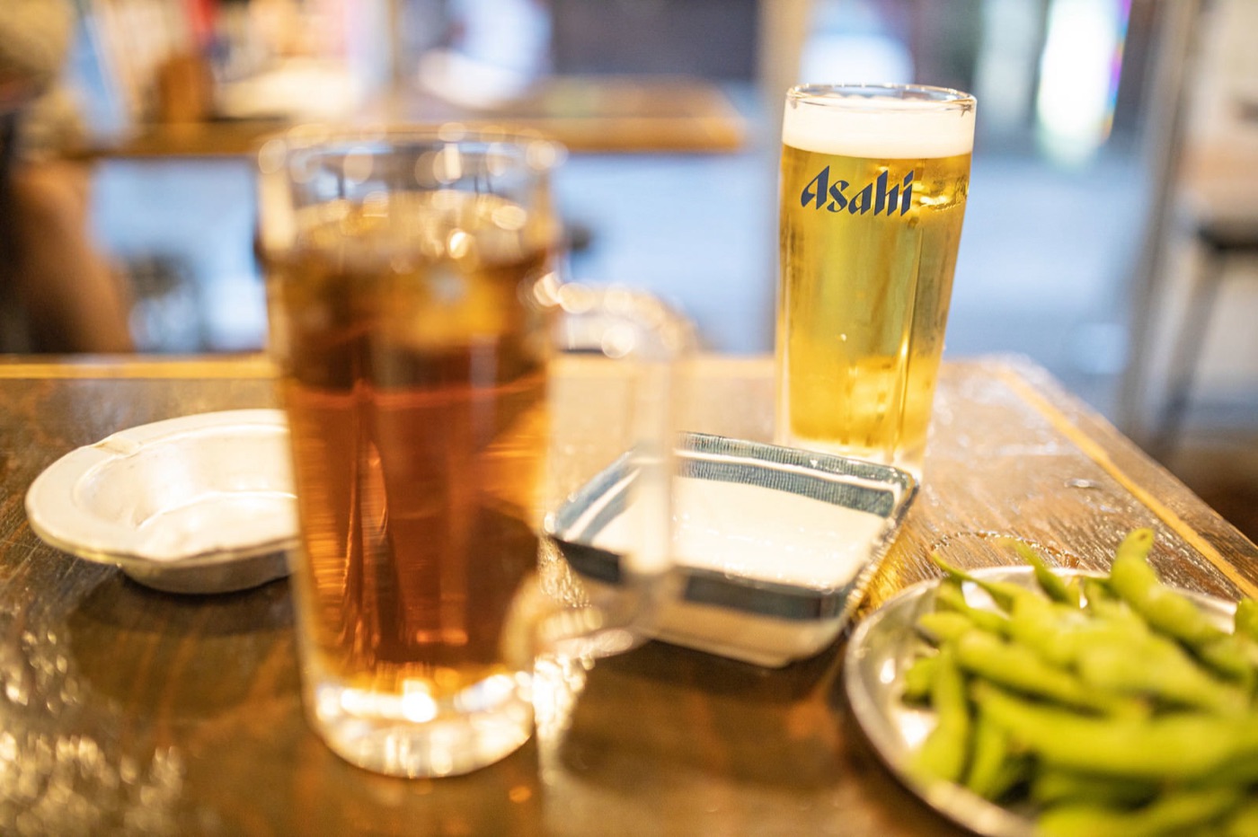 居酒屋のテーブルに並ぶ生ビールと枝豆